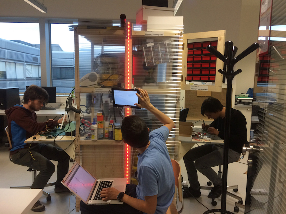 Johannes and Quentin soldering their prototypes, Sam setting up the reservation system screen.